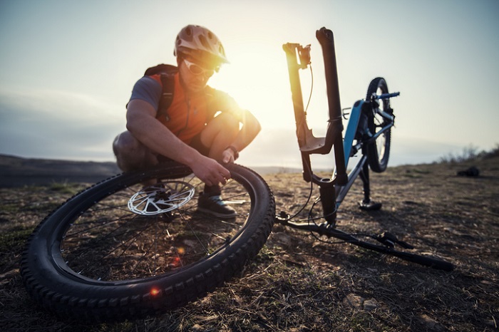 Radfahrer repariert Rad unterwegs mit Werkzeug