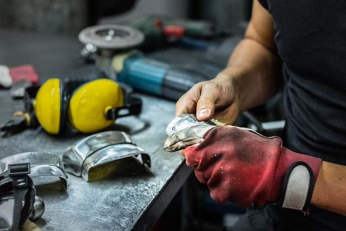 Metall reinigen: Handwerker reinigt Metall