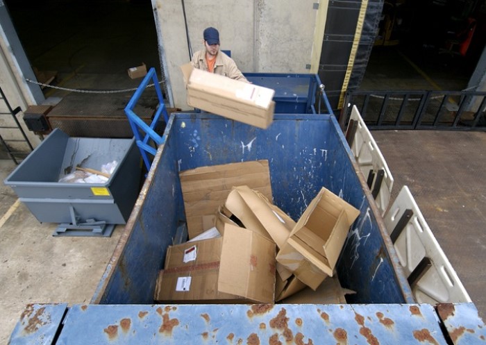 Person entsorgt Müll in Container