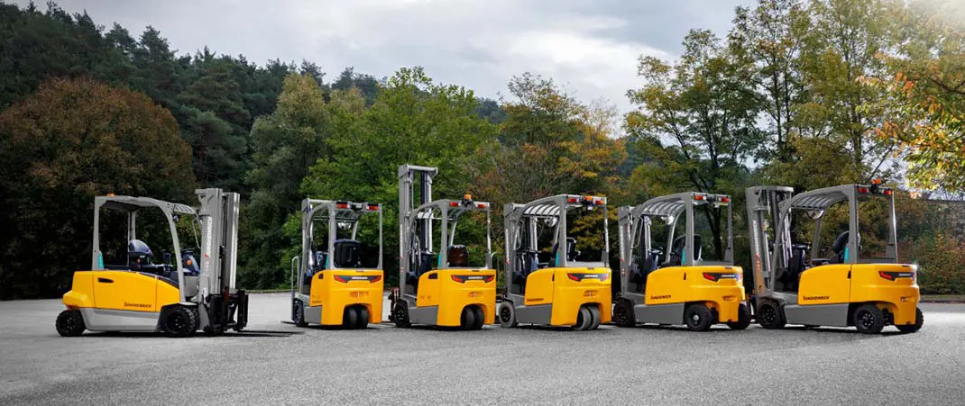 Bild verschiedener Staplerarten von Jungheinrich in einer Reihe auf einem Betriebsgelände